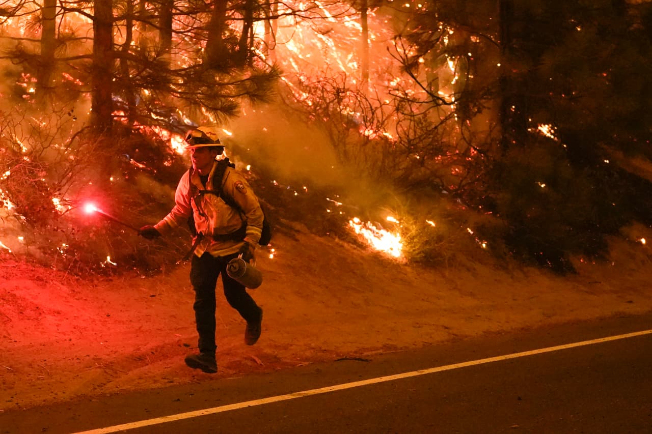 Un bombero en la carretera estatal 168 hace una quema controlada para combatir un incendio que fue nombrado Creek Fire, cerca de Fresno. Este impresionante fuego se desató el viernes y ya ha calcinado casi 55,000 hectáreas y ya ha destruido 65 estructuras.