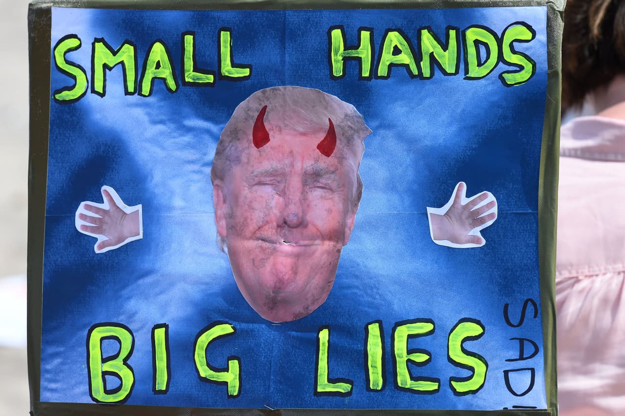 En este cartel se recuerdan las famosas manos de Trump que tan mencionadas fueron por sus opositores en los tiempos de campaña. "Manos pequeñas, grandes mentiras", dice una manifestante.