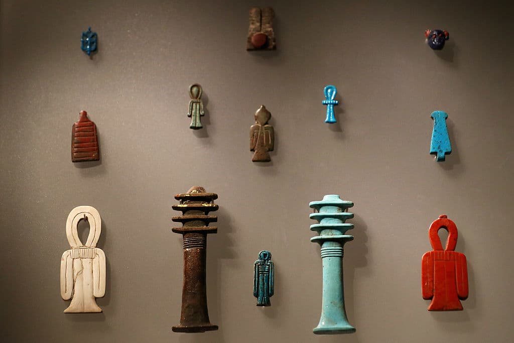 El pilar de Djed, o Dyed, como los que vemos al centro en la exhibición, simbolizaban la columna vertebral de Osiris, representado también en cetros de reyes. Se han encontrado algunos en tumbas en la espalda de las personas, y se le ha asociado también con motivos agricultores, por lo que podría haber sido usado como amuleto por el pueblo.