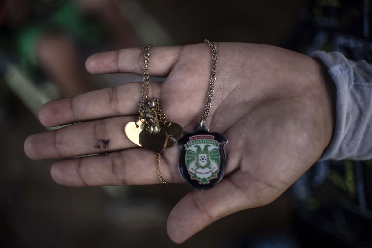 <b>Kimberli Paola</b> salió caminando de Honduras y quiere llegar hasta Miami, Florida. Dejó su país por la inseguridad y la falta de trabajo. La pertenencia más valiosa que lleva consigo es una cadena con el sello del club deportivo Marathón, un equipo de fútbol profesional de San Pedro Sula, Honduras. Mapastepec, estado de Chiapas, México. 29 de octubre de 2018