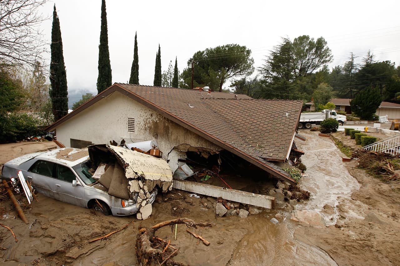 LA CANADA-FLINTRIDGE, CA - FEBRUARY 6: A debris flow damages homes and carries cars away on after heavy rains caused mudslides February 6, 2010 in La Canada Flintridge, California. Large wildfires in 2008 and 2009 stripped the hills and mountains of vegetation, resulting in mud and debris flow danger as winter rains pass over foothill communities where thousands of people have been evacuated at times in recent weeks. The threat is particularly high near the San Gabriel Mountains above La Canada-Flintridge area which were denuded of natural flood-controlling vegetation by the 250-plus square mile Station. At least 40 homes have been severely damaged and 500 remain evacuated. (Photo by David McNew/Getty Images)