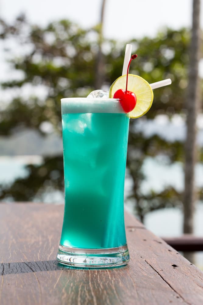 Trago de coco linda. Llego el verano que te parece llevar a la mesa estos elementos: 1 ½ parte de Midori, 1 ½ parte de coconut ron, 1 parte de blue curacao, ½ lata de jugo de piña, ½ lata de zumo de naranja y ½ lata de leche de coco. Mezclar en una licuadora todos los ingredientes, luego sirve en un vaso alto y adorna con una rodaja de naranja y una cereza.
