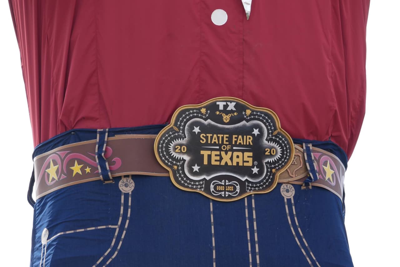 El vaquero tiene puesto su enorme cinturón con el logotipo de la Feria Estatal de Texas.