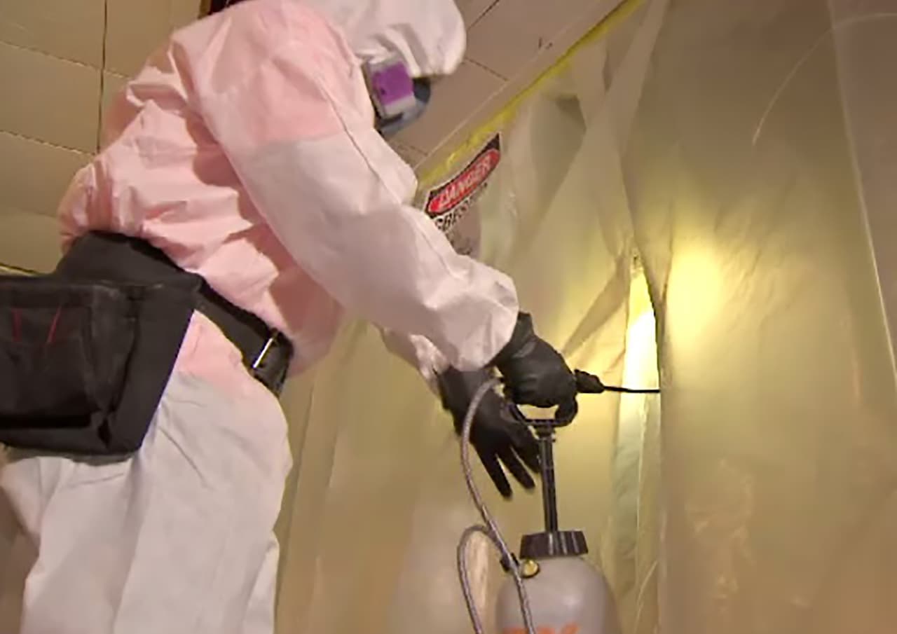 Este traje especial no es 100% seguro y los trabajadores tienen que bañarse justo después de terminar su trabajo con el asbesto. (Demostración)