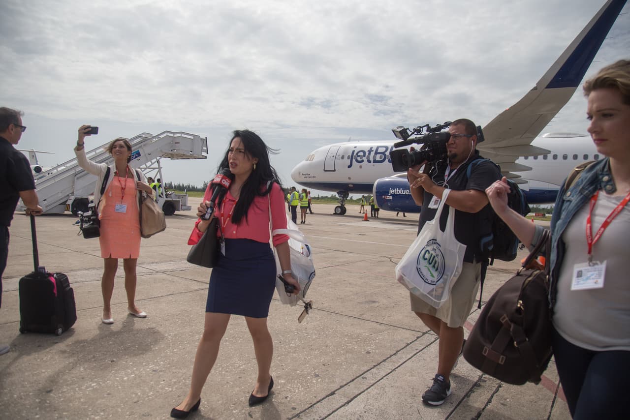 Una fila de camarógrafos y fotógrafos toman imágenes de los pasajeros al descender del avión de JetBlue en Santa Clara. El evento generó una cobertura mediática local inusitada en Cuba, reuniendo tanto a medios nacionales como a todas las agencias de prensa y corresponsales internacionales.