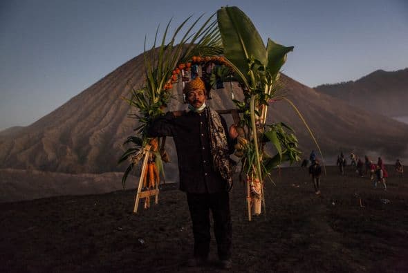 Un adorador lleva verduras como ofrenda durante el Festival Kasada Yadnya en cráter del monte Bromo, en Indonesia.