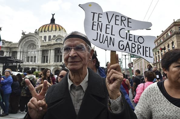 People gather outside the Palace of Fine Arts to pay tribute to Mexico's late Latin music legend Juan Gabriel, in Mexico City, on September 5, 2016. The singer known as the "Divo of Juarez," who touched millions with wrenching ballads of love and loneliness, died of a heart attack at age 66 on August 28 at his home in Santa Monica, California during a break in his latest tour. The urn will be placed in the hall of the marble palace for people to pay tribute to the star until Tuesday, the culture ministry said. / AFP / Yuri CORTEZ (Photo credit should read YURI CORTEZ/AFP/Getty Images)