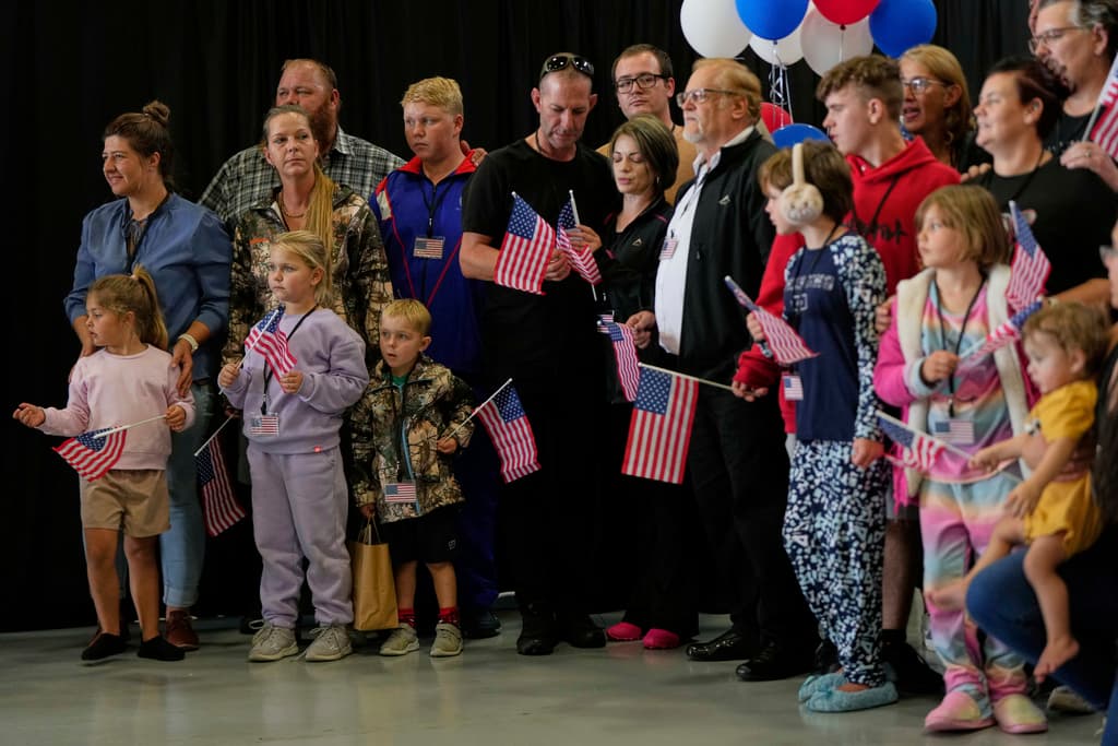 Refugiados afrikáneres de Sudáfrica con banderas estadounidenses llegan al Aeropuerto Internacional Dulles, Virginia, el lunes 12 de mayo de 2025.