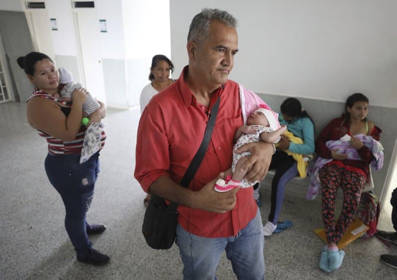 Former Venezuelan police officer Eduardo Bravo cradles his baby Aranza Gabriela Bravo as they wait at the Erazmo Meoz hospital to get her birth certificate in Cucuta.