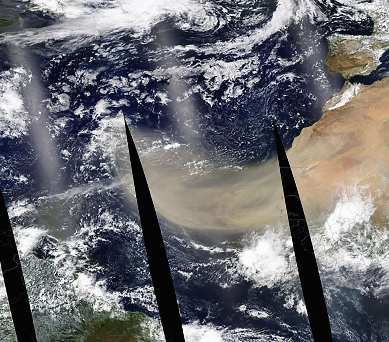 Esta imagen de la nube de arena fluyendo a más de 1,500 millas sobre el océano Atlántico fue tomada el 18 de junio desde el
<a href="https://modis.gsfc.nasa.gov//gallery/individual.php?db_date=2020-06-21" target="_blank">satélite Aqua de la NASA</a>. Las franjas negras son las áreas donde no se recopilaron datos en múltiples pases del satélite sobre el océano.
<br>