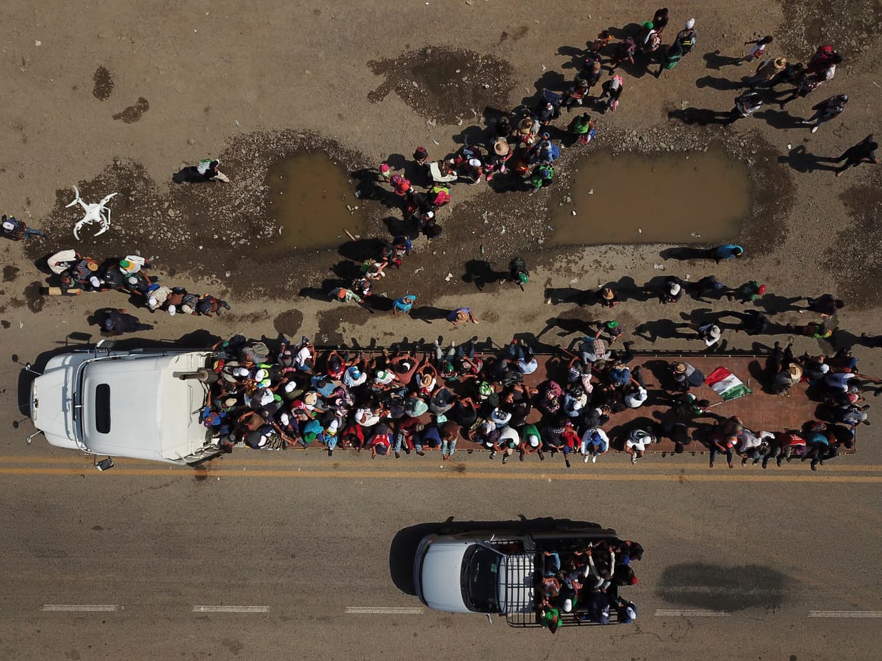 Decenas de migrantes suben a un remolque mientras otros hacen fila para tomar el próximo que los llevará a Niltepec, en el estado mexicano de Oaxaca. La caravana de migrantes que salió de Honduras el 13 de octubre ha puesto de relieve la ola de migrantes centroamericanos. Algunos esperan continuar hasta la frontera con EEUU y otros han aceptado recibir beneficios en México.