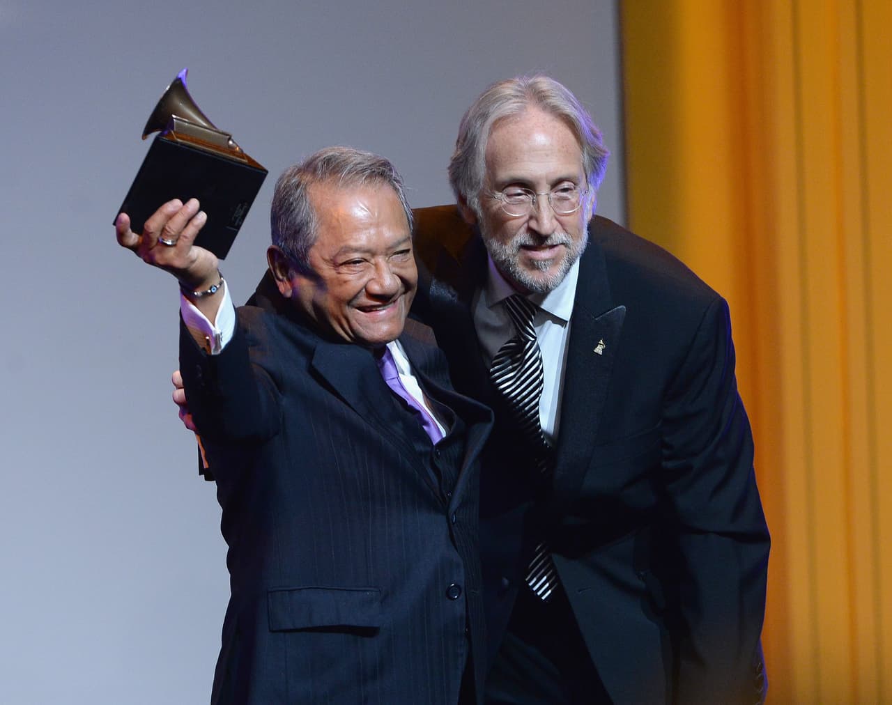 Entre los múltiples galardones del compositor está el Grammy Latino a la trayectoria que recibió en 2010. Luego recibiría el Premio Grammy general por su carrera, en 2014. En la fotografía recibiendo este premio de Neil Portnow, presidente de la Academia de Grabación estadounidense.