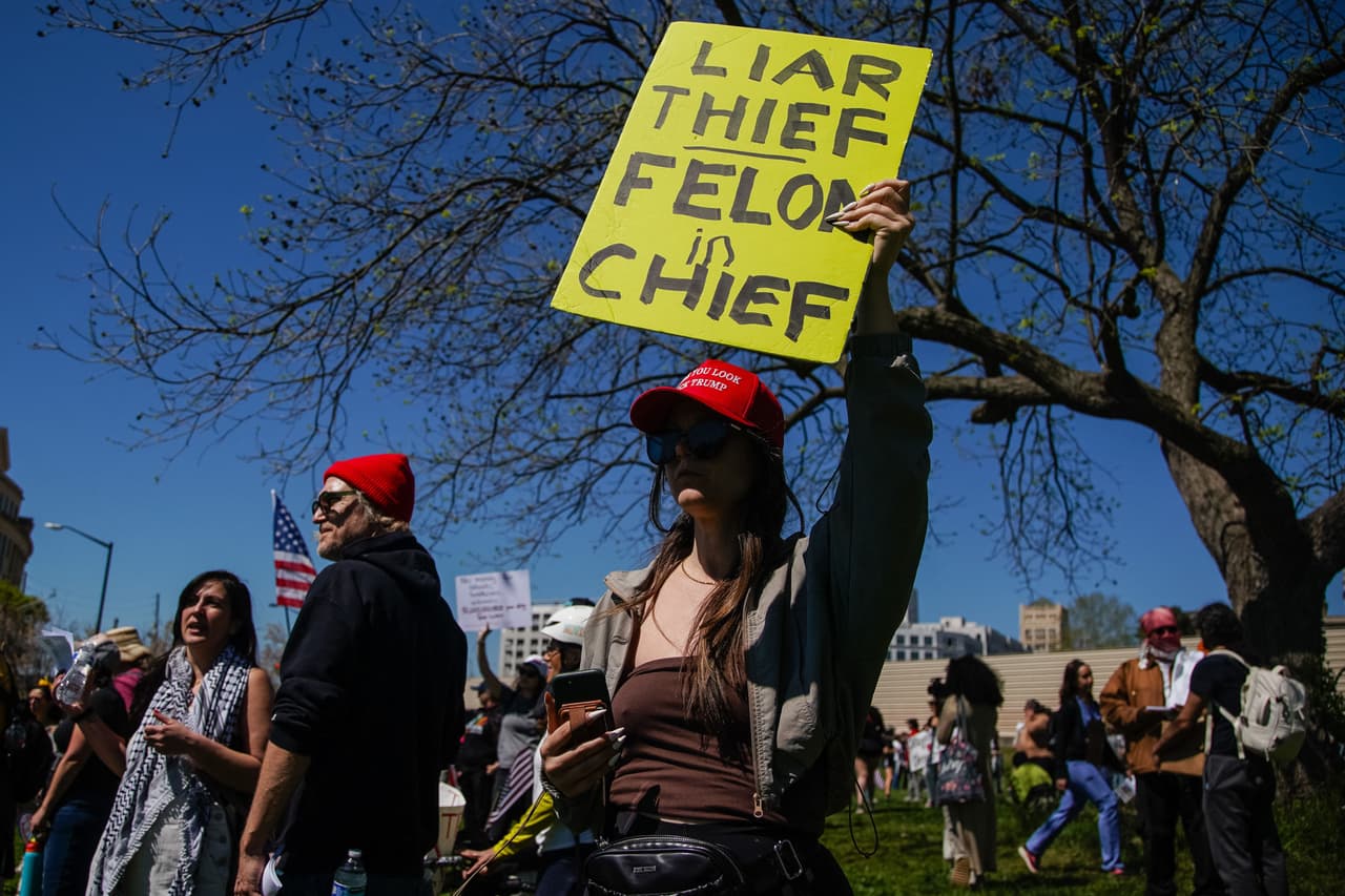 Una persona sostiene un cartel que dice “mentiroso, ladrón, delincuente en jefe”. Millones de personas expresan su furia ante lo que consideran su tendencia autoritaria y otras formas de gobierno cruel que violan la ley.