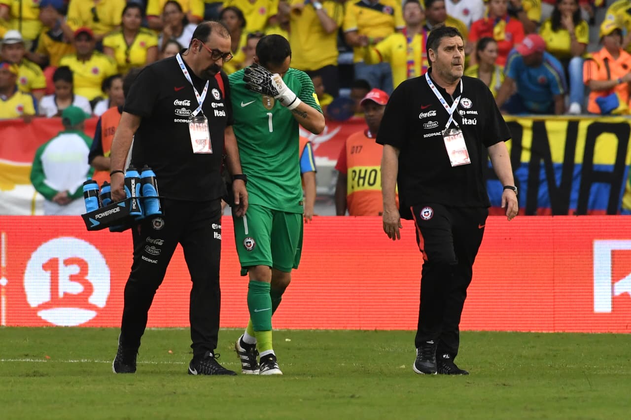 Chile's goalkeeper Claudio Bravo (C) leaves the field in pain during the 2018 FIFA World Cup qualifier football match against Colombia in Barranquilla, Colombia, on November 10, 2016. / AFP / Luis Acosta (Photo credit should read LUIS ACOSTA/AFP/Getty Images)