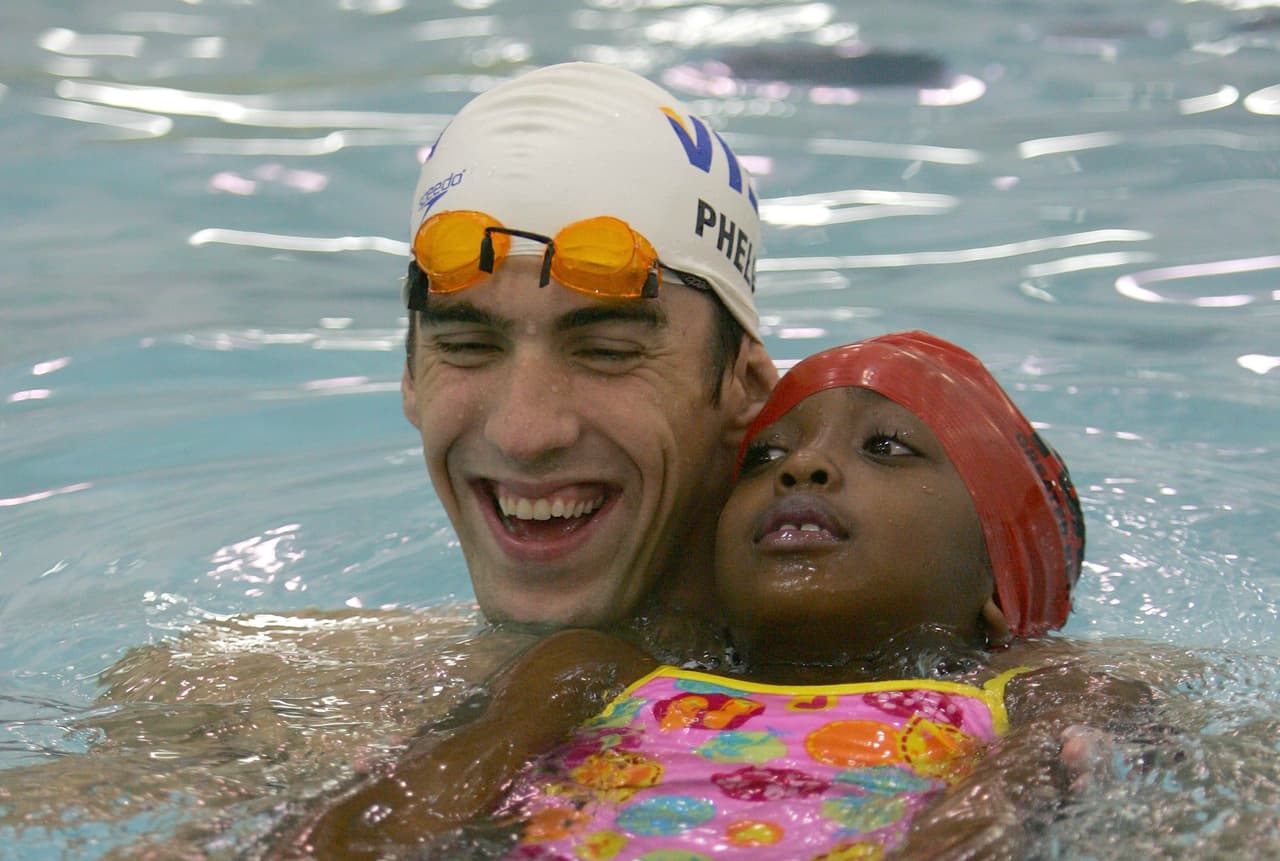 El campeón visita un centro de niños atletas YMCA, en Nueva York, el 28 de agosto al llegar de China.