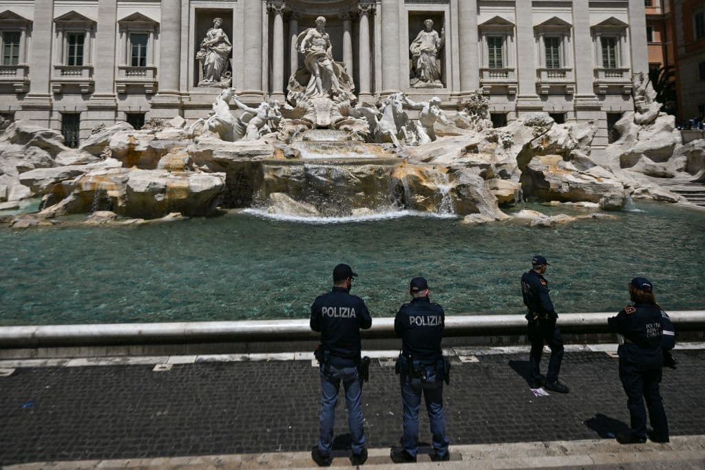 La policía italiana frente a la Fuente de Trevi, en Roma, el pasado domingo 21 de mayo. El grupo ambientalista Ultima Generazione pintó las aguas de la famosa fuente de negro con un carbón vegetal, con el objetivo de criticar la política del gobierno italiano sobre el cambio climático. 
<br>