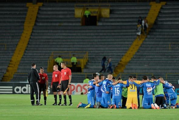 Los jugadores del club Millonarios rezan después de un partido contra el equipo de Fortaleza, como parte de la Liga colombiana de futbol.
