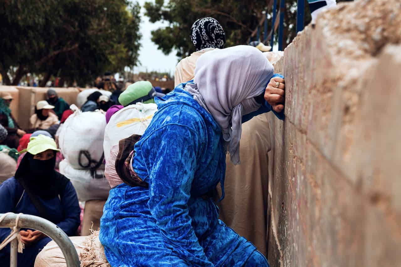 Los comerciantes de Melilla pagan a los ‘porteadores’, de nacionalidad marroquí, de cuatro a once dólares, y hasta 20 durante el invierno, por cada bulto de 80 kilos de mercancía que llevan a su país. En la fotografía de junio de 2018, una ‘porteadora’, que comenzó su turno de trabajo a las 3:00 AM, espera que las autoridades españolas abran la frontera.