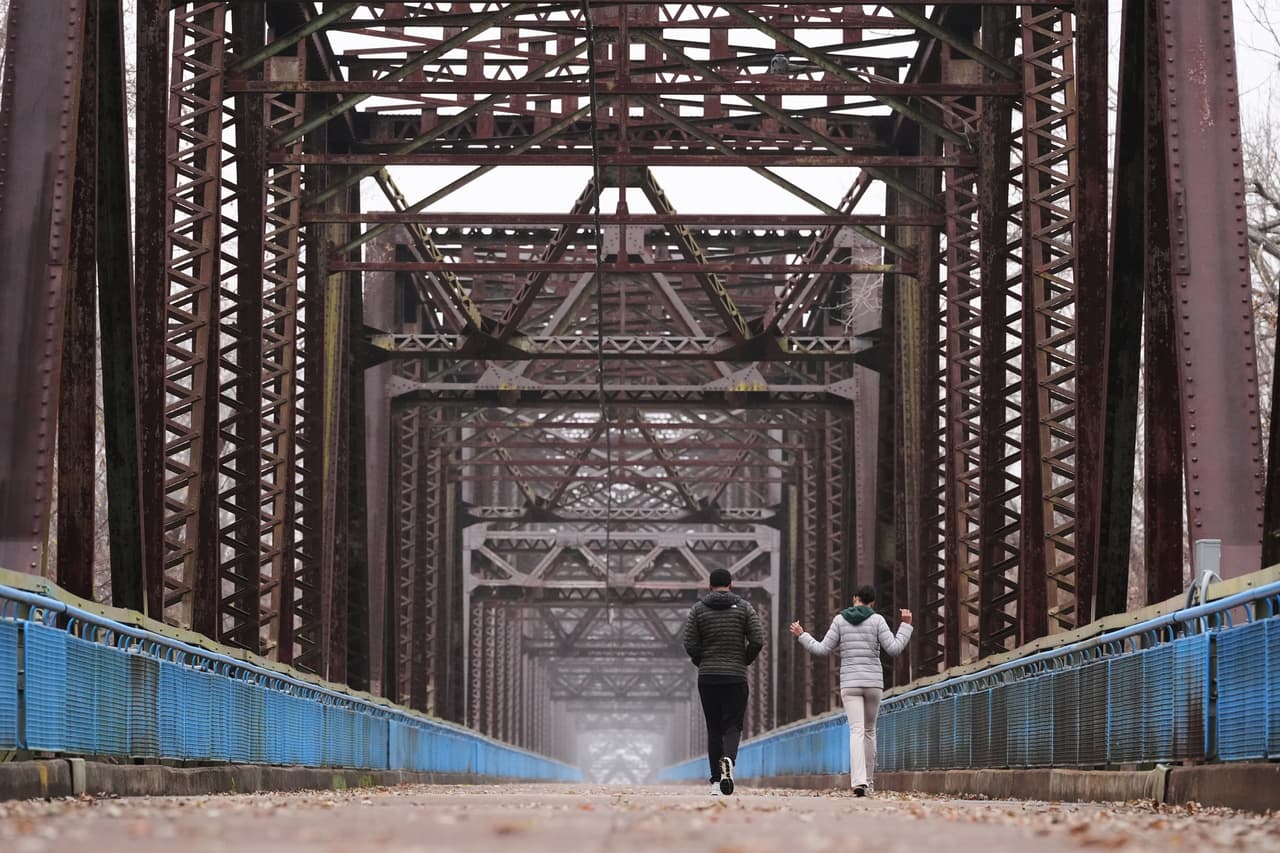 Reygan Calloway, a la derecha, y su novio Jordan Smith caminan a través del puente Old Chain of Rocks, que cruza el río Misisipi desde Illinois hasta Misuri y que ahora forma parte de la Ruta Ciclista 66 en Madison, Illinois.