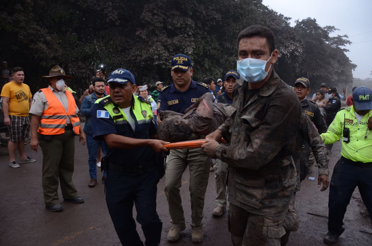Un grupo de trabajadores de los equipos de rescate de Guatemala trasladan a un herido en El Rodeo, Escuintla, Guatemala.
