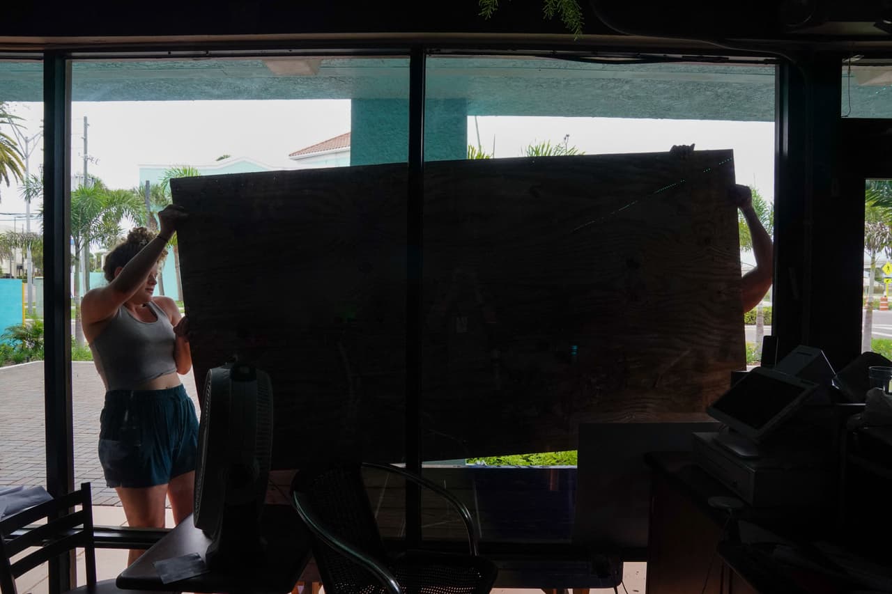 Esta pareja protege con paneles de madera su restaurante en Clearwater Beach, Florida.