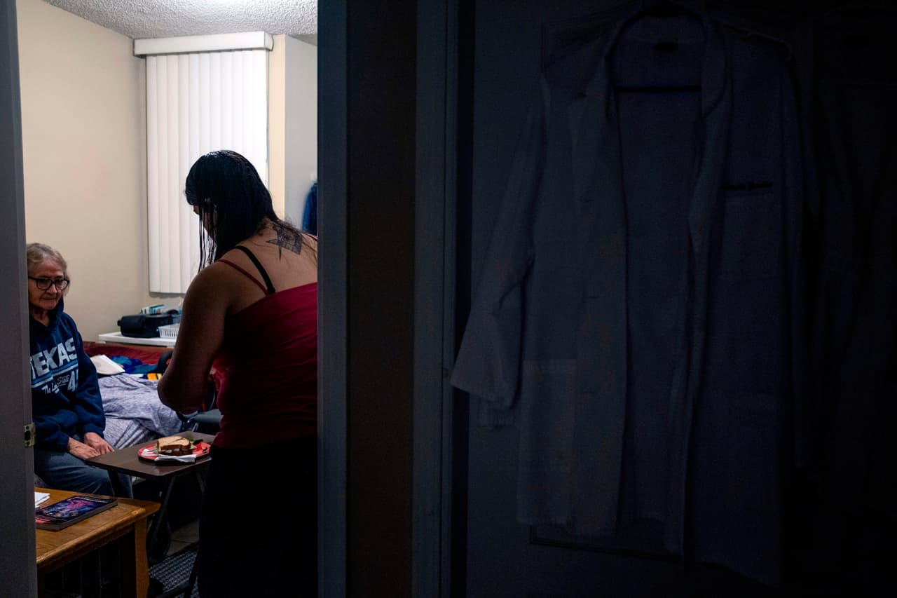 La doctora Estrella González, de 37 años, sirve la cena a su madre María Inés, de 75 años, antes de partir hacia el Hospital General Fray Junipero Serra en Tijuana.