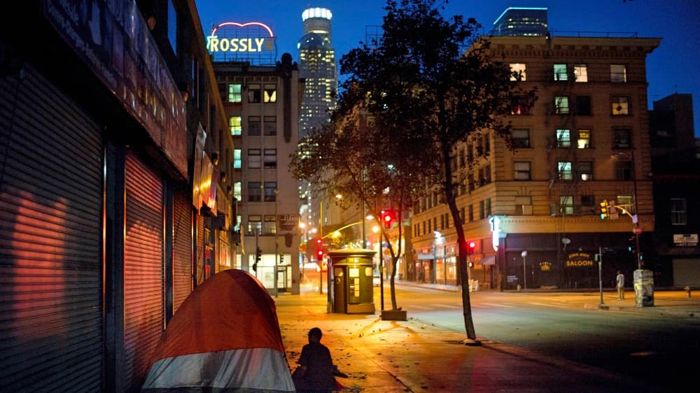 Daniel Shawn, de 48 años, instala su carpa en una calle, al frente con la panorámica de uno de los rascacielos de Los Ángeles.