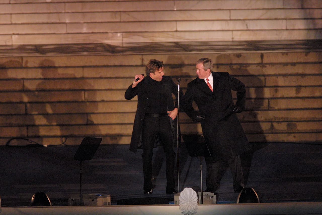 George W. Bush, hijo del expresidente, sucedió a Bill Clinton. En esta fotografía del 20 de enero de 2001 el nuevo presidente baila con el cantante Ricky Martin. Los conciertos también se establecieron como una tradición del día de la ceremonia inaugural de los presidentes y en la toma de posesión de Biden se realizarán sin público.