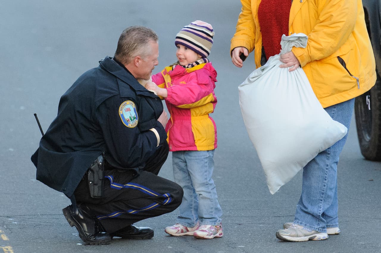 <b>2012. Escuela primaria Sandy Hook en</b> 
<b>Newtown, Connecticut.</b> Adam Lanza, un joven de 20 años de edad, entró disparando a la primaria local de Newtown, la ciudad donde vivía.
<a href="https://www.univision.com/noticias/tiroteos/en-fotos-a-cinco-anos-de-la-matanza-en-la-escuela-primaria-sandy-hook-fotos"> Asesinó a 20 niños y seis adultos, entre alumnos y maestros de la escuela</a>. Antes había matado a su propia madre y al final se suicidó. En la fotografía, un sobreviviente de la matanza saluda a un policía al salir de la escuela primaria. 14 de diciembre de 2012.