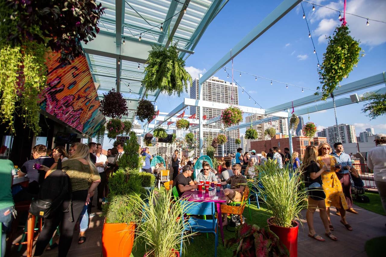 <b>Utopian Tailgate en Old Town</b>
<br>Este divertido lugar de 10,000 pies cuadrados en lo alto del legendario Second City abrió con mucha fanfarria el verano pasado y sigue siendo una de las opciones al aire libre más populares de la ciudad. 
<b><a href="https://www.univision.com/local/chicago-wgbo/girasoles-condado-lasalle-parque-matthiessen-fotos">Resplandeciente en colores vibrantes</a></b> y repleto de juegos para grupos como el gigante Connect Four y Cornhole, irradia el mismo tipo de alegría que alimenta el resto del edificio emblemático, donde comenzaron algunos de los comediantes más elogiados del mundo. Pasa por aquí para disfrutar de deliciosa comida y bebidas tropicales mientras te relajas con estilo en las sillas Adirondack en tonos neón. Visita 
<a href="http://www.utopiantailgate.com">www.utopiantailgate.com</a> 
<br>