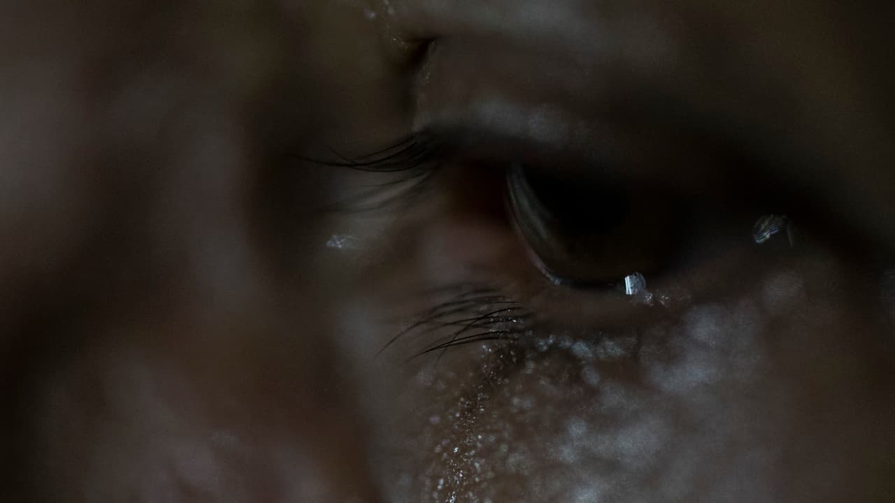 La abuela llora en su casa en una zona rural de El Salvador. Ni ella ni los miembros de su familia que siguen aquí pueden salir a trabajar. Viven con constante temor a las amenazas y la muerte. "A nosotros nos ha pasado de todo. Solo falta que nos muramos ya", solloza, describiendo palizas, "pero que no sea así, ¿verdad? Cruelmente".