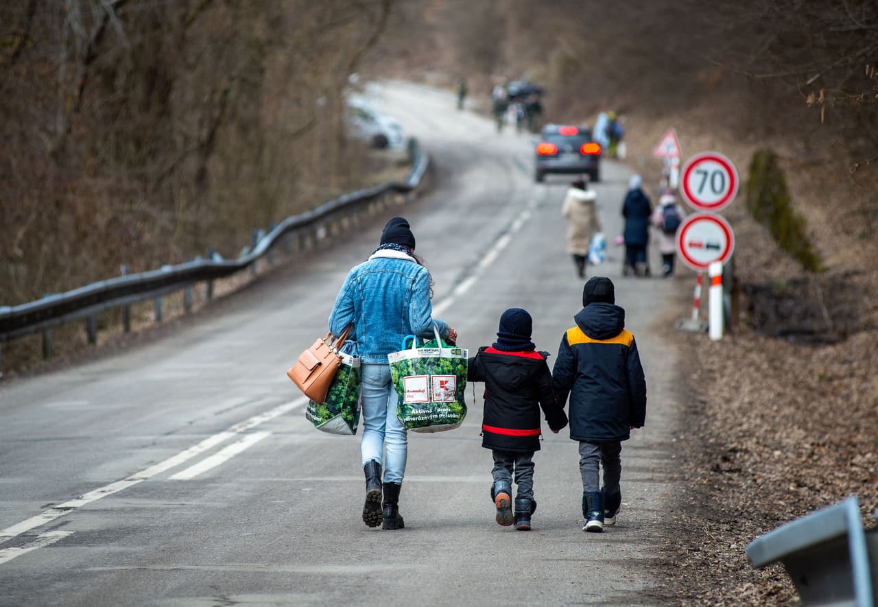 Una mujer con dos niños camina por una carretera después de cruzar la frontera desde Ucrania a Eslovaquia, el 25 de febrero. La Agencia de las Naciones Unidas para los Refugiados (ACNUR) calcula que en las primeras horas de la invasión rusa al menos 100,000 ucranianos ya habían tenido que dejar sus hogares. 
<br>