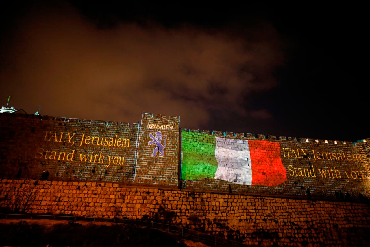 <b>La bandera italiana</b> proyectada en las paredes de las murallas de la Ciudad Vieja de Jerusalén, Israel, en señal de apoyo a los que sufren de coronavirus en Italia. 15 de marzo.