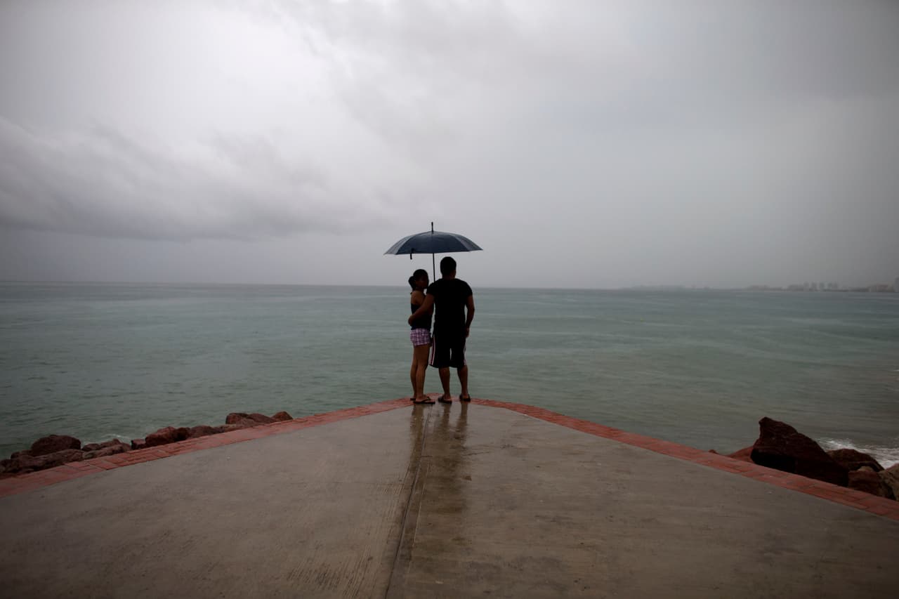 Mirando el horizonte, una pareja momentos previos a la llegada de la tormenta.