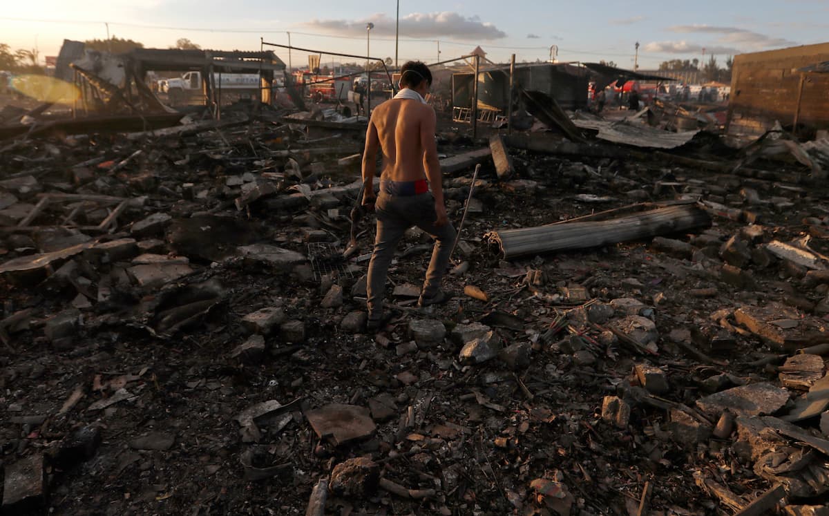 Un hombre camina sobre los escombros de lo que fue el mercado de piroténicos de Tultepec, al norte de Ciudad de México