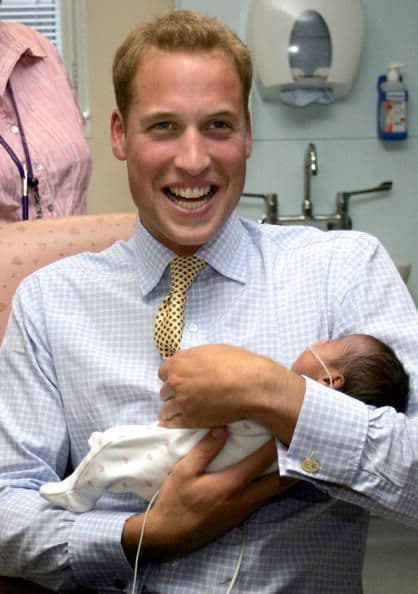 El príncipe William carga a un bebé en la Unidad de Winnicott, en Londres.