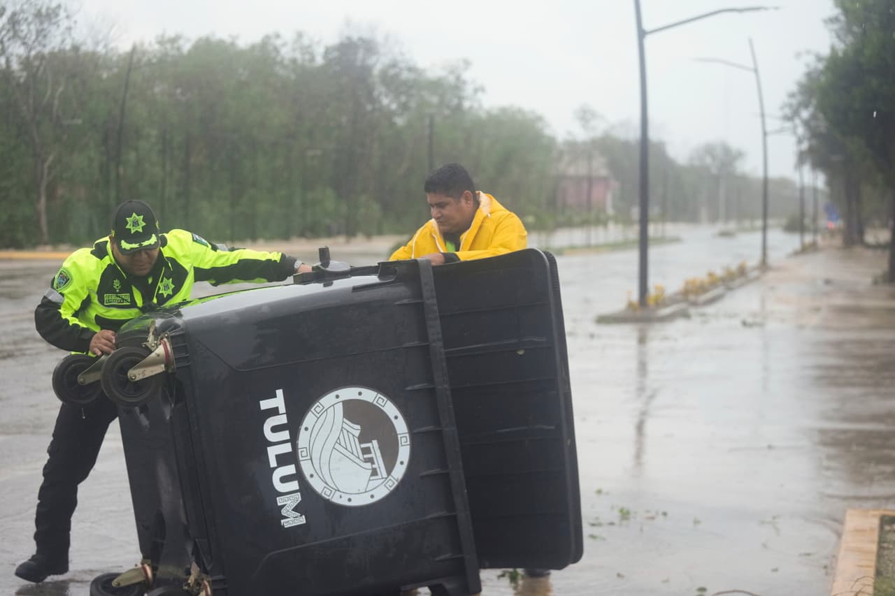 Un policía y un trabajador en Tulum, México, el viernes 5 de julio de 2024, cuando la zona se encuentra bajo los efectos del huracán Beryl.
<br>