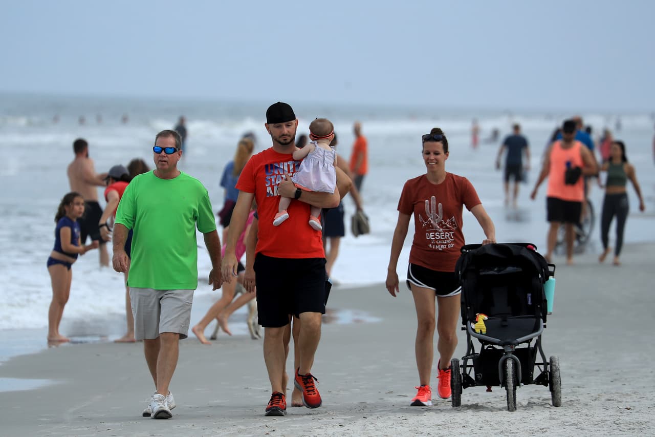 Residentes de Jacksonville, Florida, caminaban por la playa el 19 de abril. El gobernador de ese estado, Ron DeSantis, dio luz verde para que algunas playas y parques reabran de forma segura manteniendo las reglas de distanciamiento social.