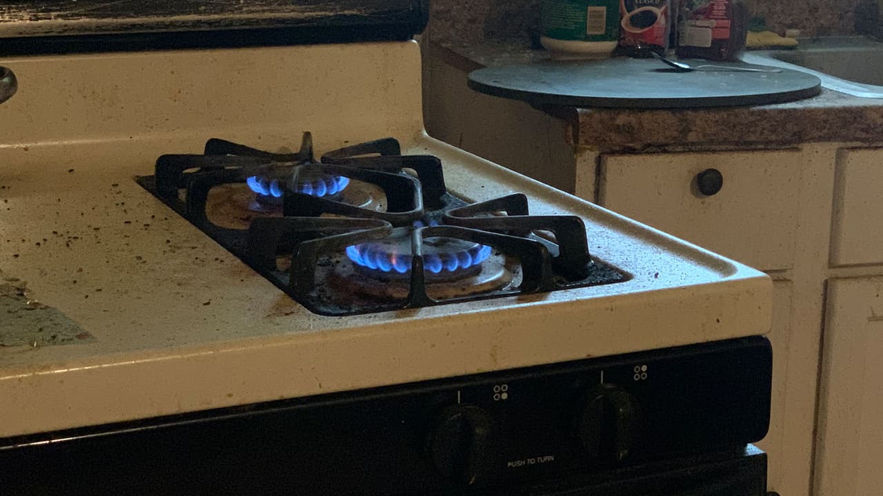 Como no tiene un aparato de calefacción, Emilio usa la estufa para darse un poco de calor ante las frías temperaturas.