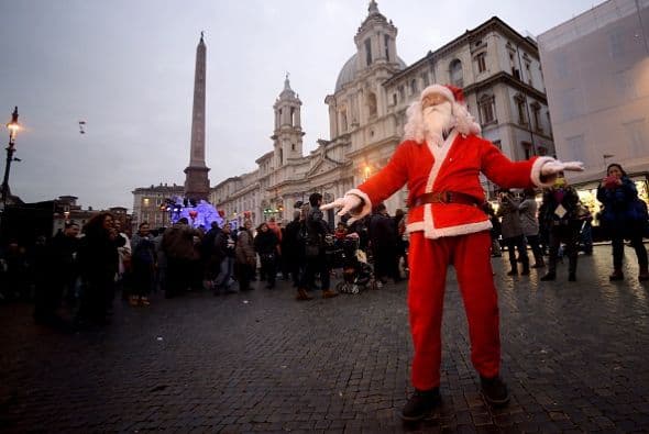 Un hombre vestido como Santa Claus baila en el centro de la Piazza Navona de Roma.
