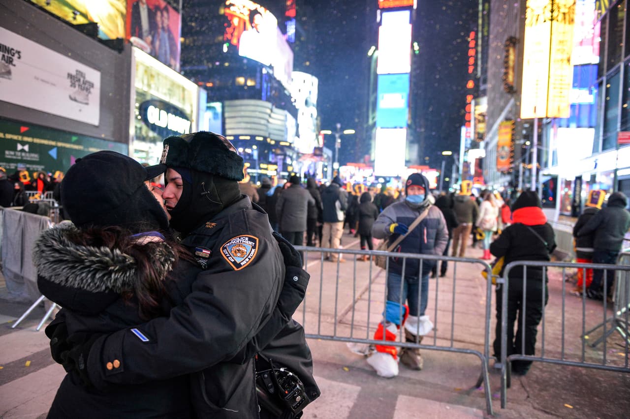 A pocos minutos de dar las 12 de la noche del 31 este policía abraza y besa a su pareja en el Times Square, Nueva York, donde se ha reunido la gente para celebrar la llegada de 2018.