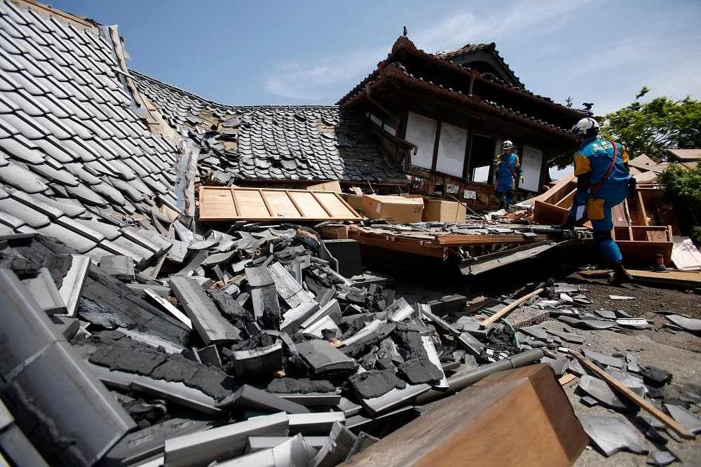 Rescatistas buscan supervivientes entre las casas caídas por el terremoto en la prefectura de Kumamoto, en Japón.