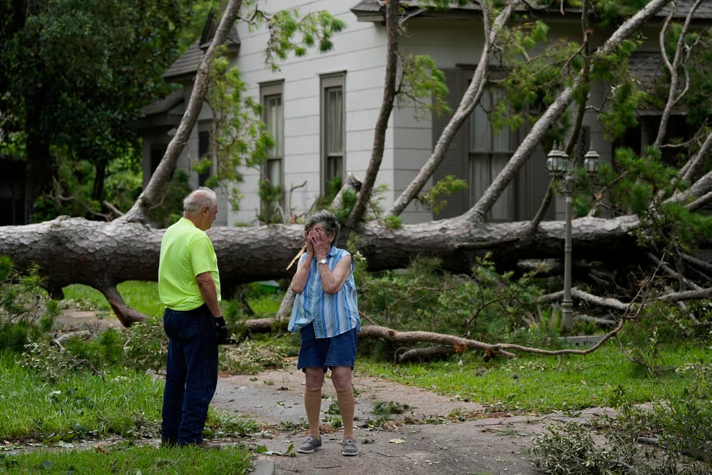 Jackie Jecmenek, a la derecha, habla con el trabajador de la ciudad Bobby Head mientras se encuentra frente a la casa de su vecino después de Beryl pasó, lunes, 8 de julio de 2024, en Bay City, Texas.
