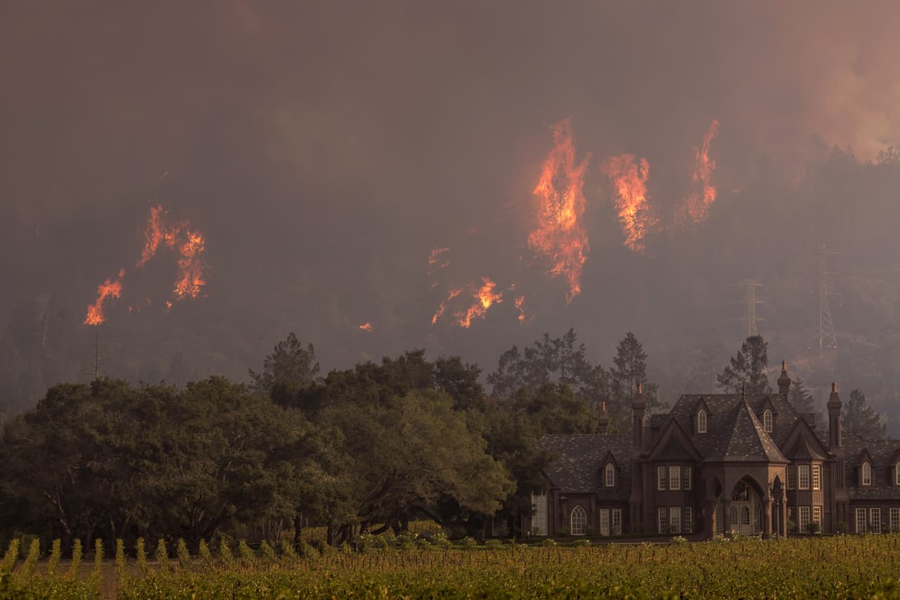 Las llamas se elevan por detrás de la bodega y viñedos Ledson, en Sonoma, California. La industria de los vinos ha sido severamente golpeada por el fuego.