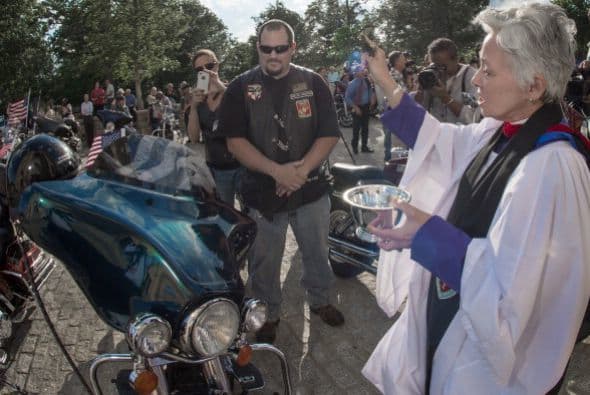 Esta reverenda rocía agua bendita en una motocicleta Harley Davidson en la Catedral Nacional de Washington.