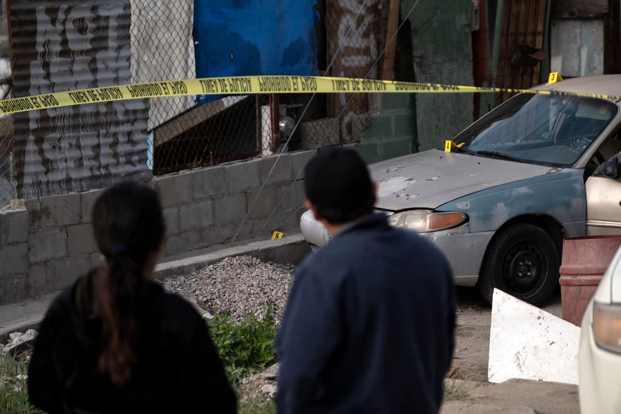 María Elena Frausto (izquierda), viuda del fotoperiodista Margarito Martínez, observa la escena del crimen frente a su casa en Tijuana, México.