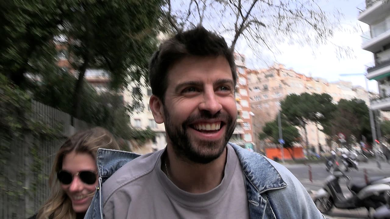 Clara Chía se golpea con un cartel publicitario en la vía pública intentando ocultarse de la prensa, mientras ambos se ríen a carcajadas frente a la situación.