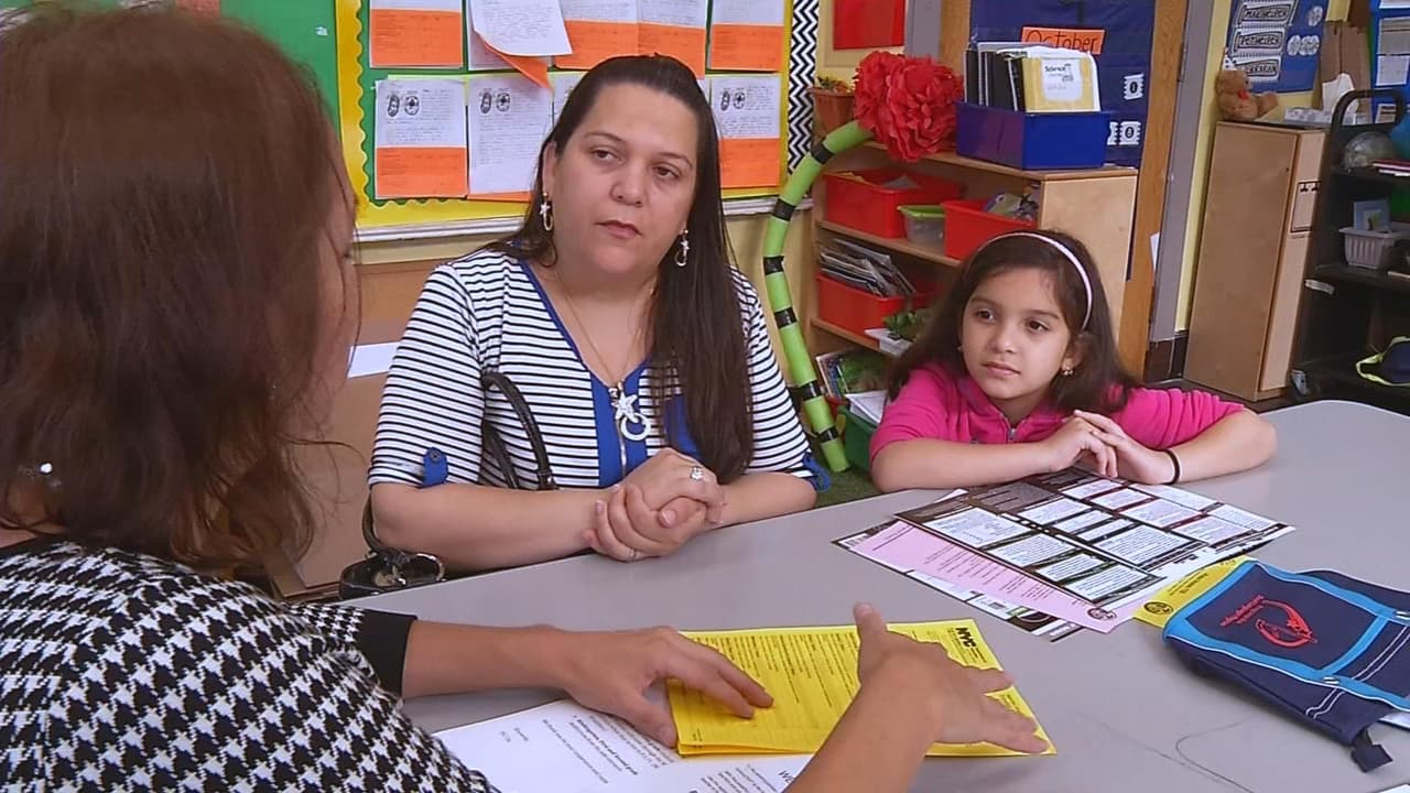 Arlette y su mamá escuchan atentamente a una de las profesoras de la escuela.