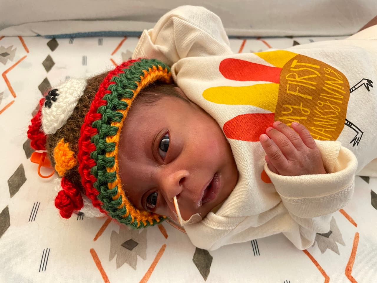 Con su gorrito tejido y sus guantes, este bebé posa para la cámara.