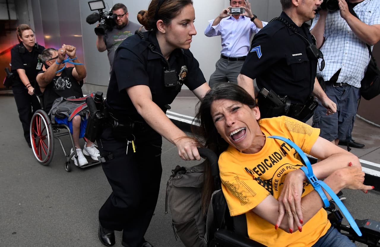 Defienden sus derechos como discapacitados y están liderando las protestas en contra de 
<a href="http://www.univision.com/noticias/medicaid/jason-tiene-9-anos-es-autista-epileptico-y-depende-de-medicaid-su-caso-muestra-como-los-recortes-afectarian-a-millones-de-estadounidenses?q">los recortes a Medicaid</a>, incluidos en el proyecto de ley de salud que se discute en el Senado. En la imagen, Dawn Russell es arrestada por la policía de Denver después de negarse a abandonar la oficina del senador Cory Gardner en la capital de Colorado a finales de junio. Los miembros del grupo ADAPT permanecieron 58 horas en el pequeño lobby de la oficina, para pedirle que vote en contra del proyecto de ley. Cantaban: 
<b>"Preferiría ir a la cárcel que morir sin Medicaid"</b>.